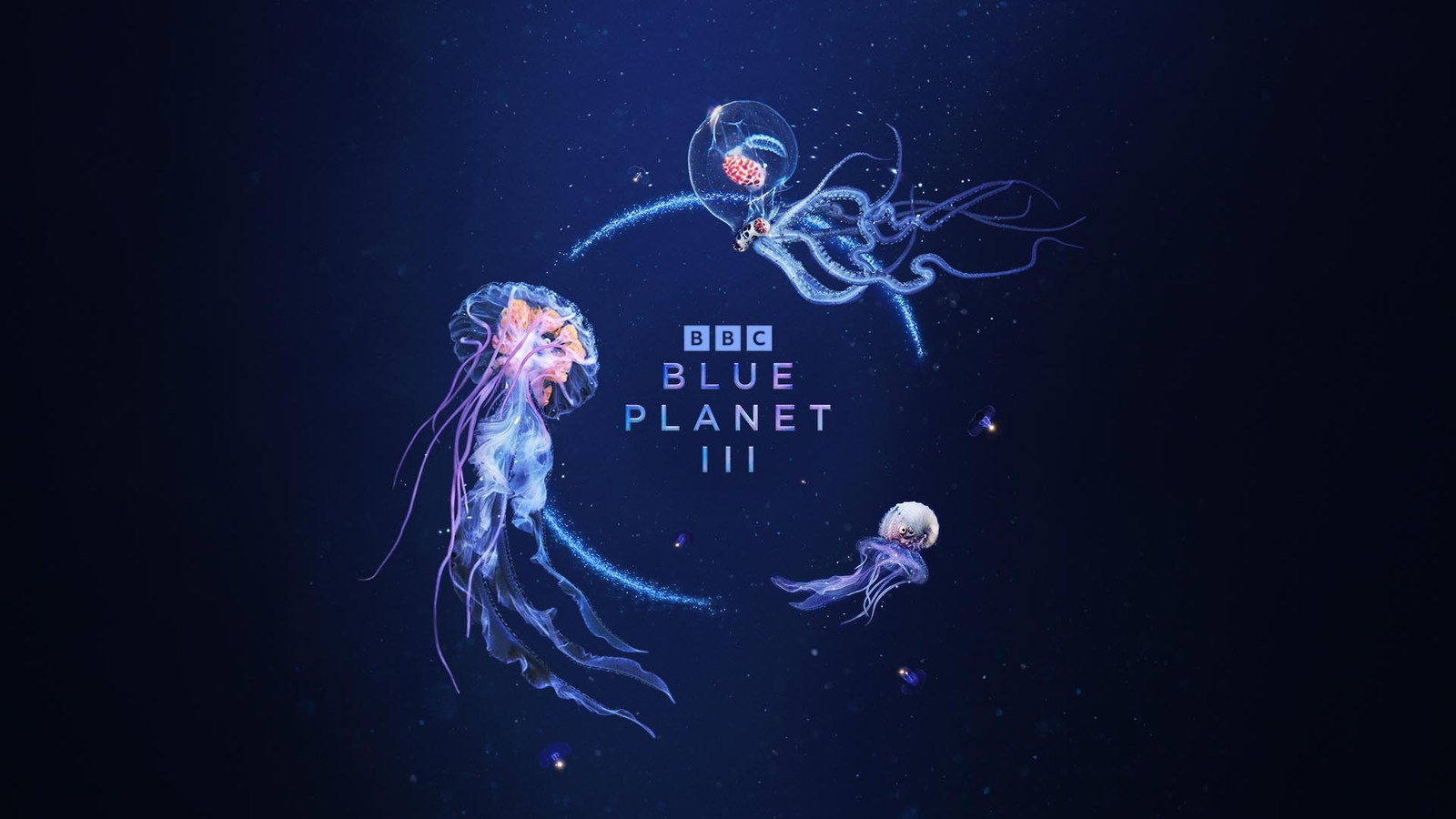 Official Blue Planet III key art from BBC Studios: glowing jellyfish and a small octopus circling the BBC Blue Planet III title against a deep blue ocean