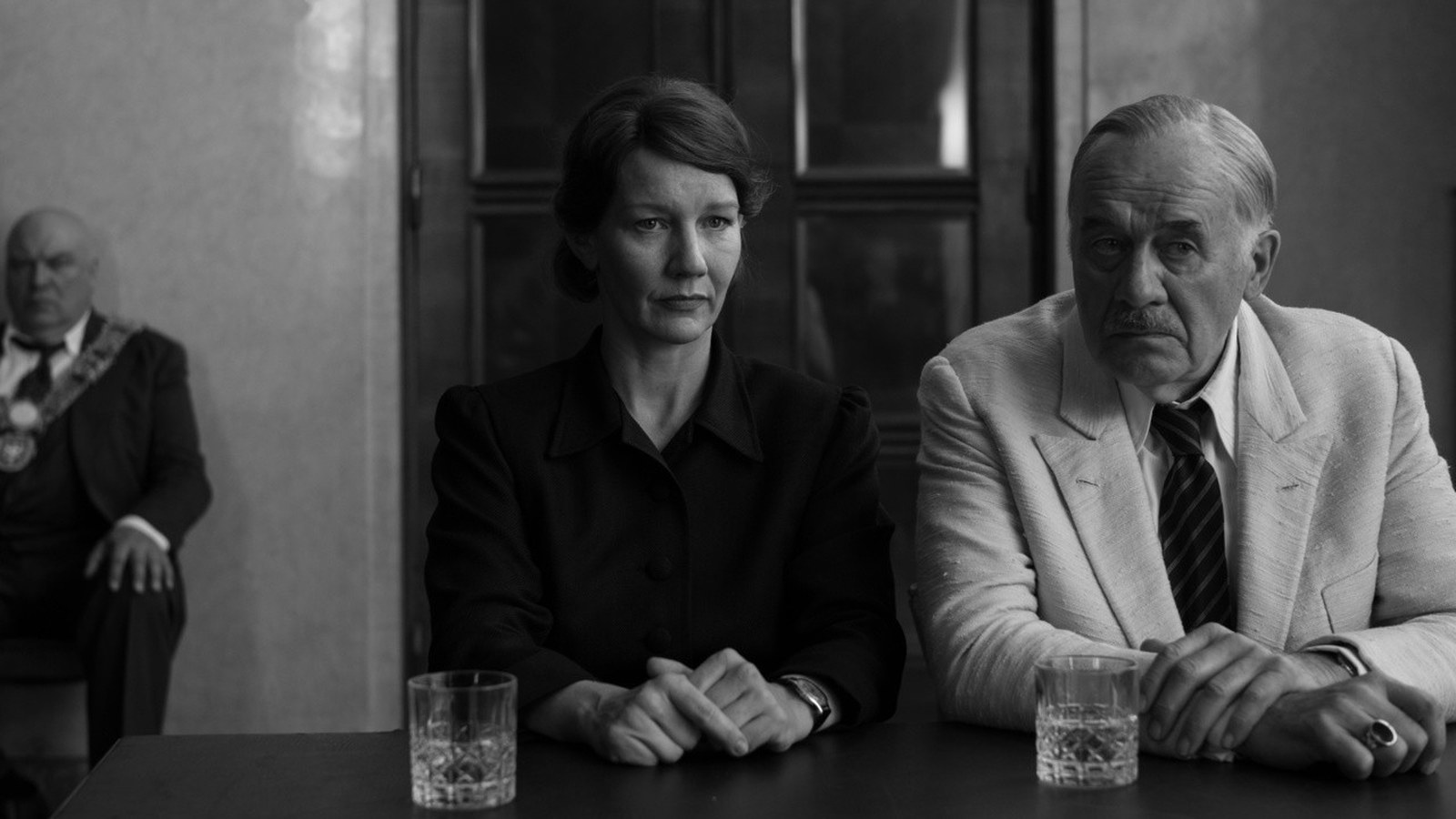 Official black-and-white Fatherland image of Sandra Hüller and Hanns Zischler seated at a table