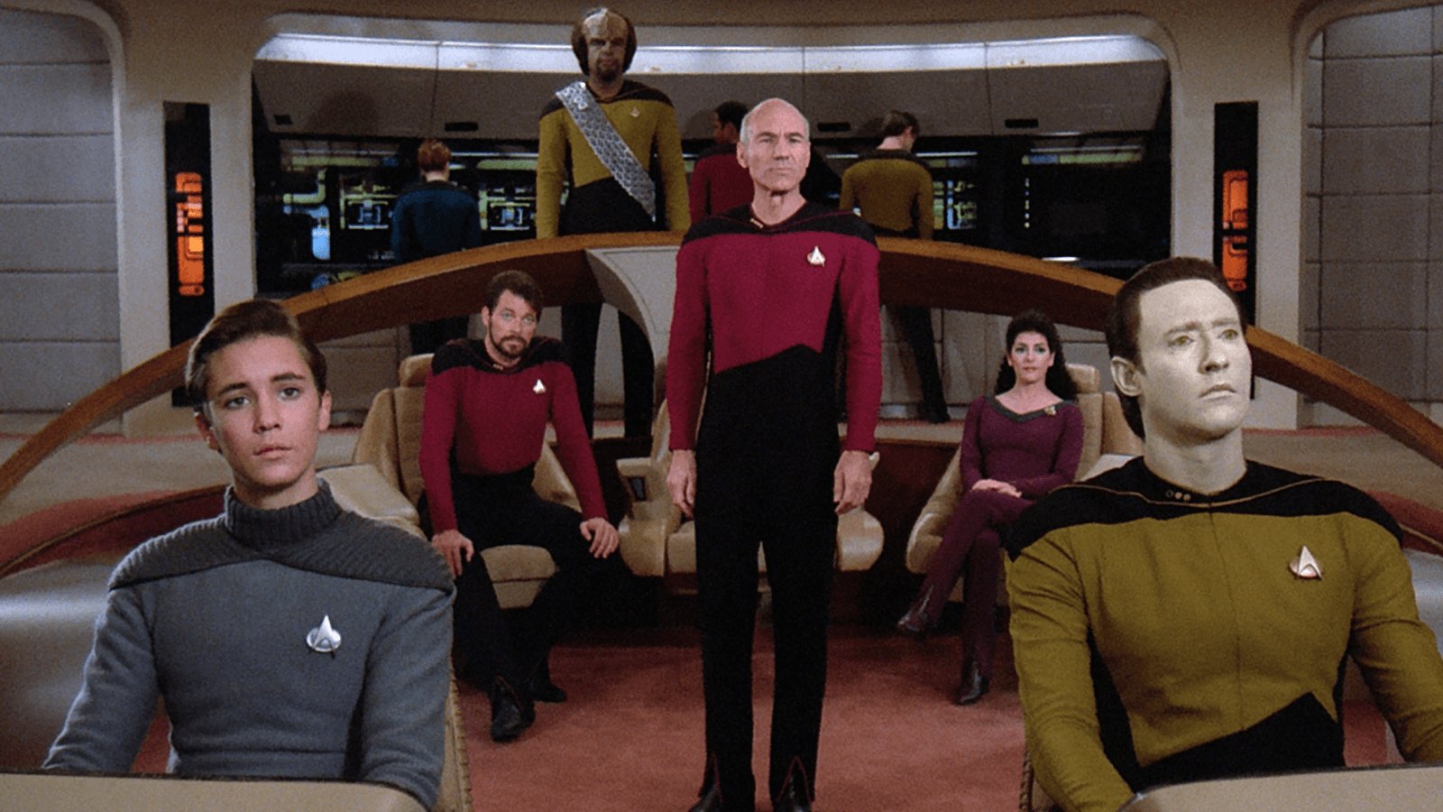 Patrick Stewart as Captain Jean-Luc Picard standing on the bridge of the Enterprise with the crew of Star Trek: The Next Generation
