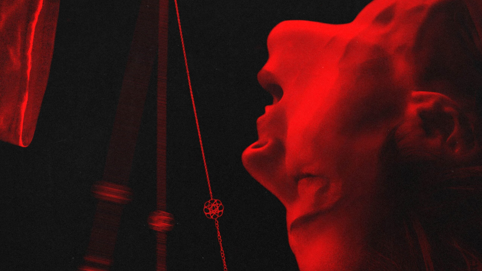 Pendulum official artwork: a woman bathed in red light tilts her head back as a pendulum swings beside her
