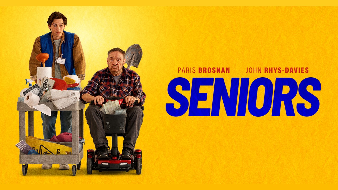 Seniors official artwork showing Paris Brosnan with a cleaning cart and John Rhys-Davies on a mobility scooter against a yellow background