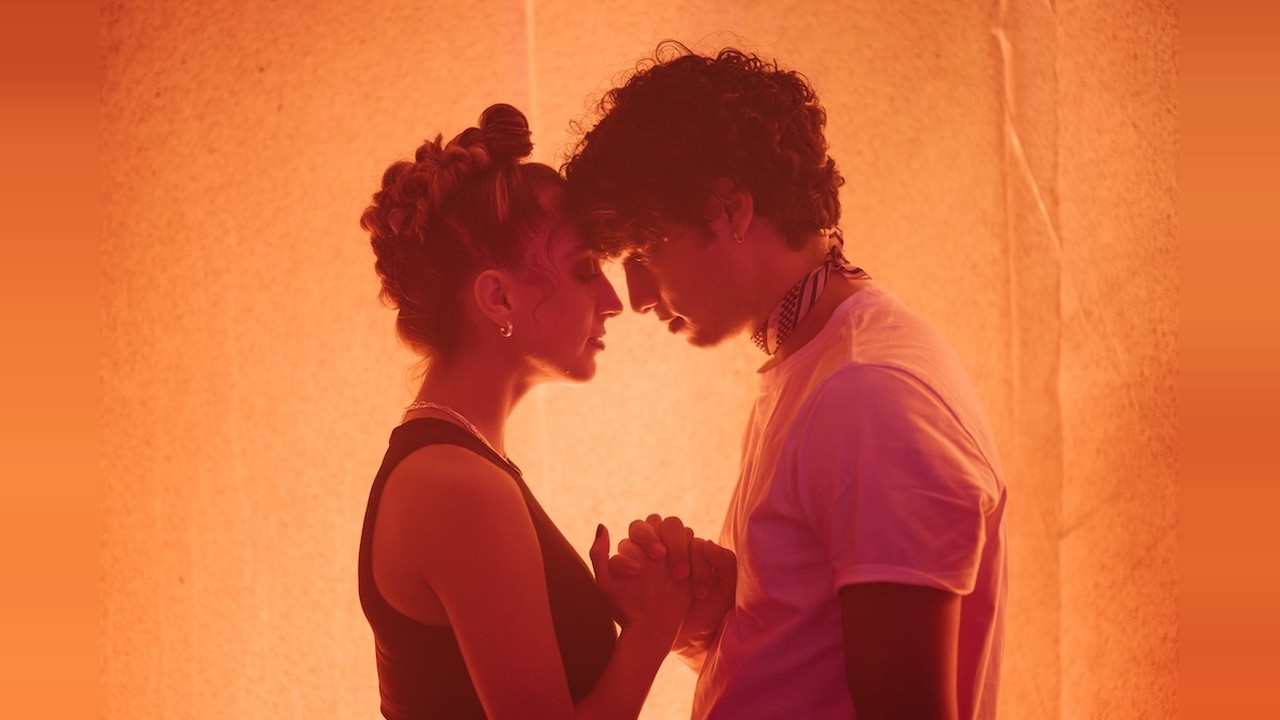 These Violent Delights official still of two dancers touching foreheads against a glowing orange wall